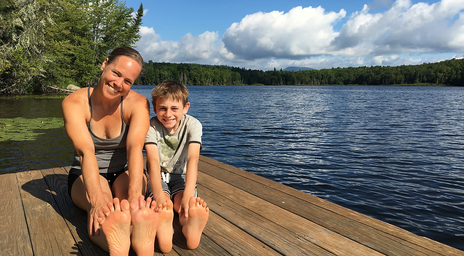 Jen Stone practicing yoga on a dock by a peaceful lake